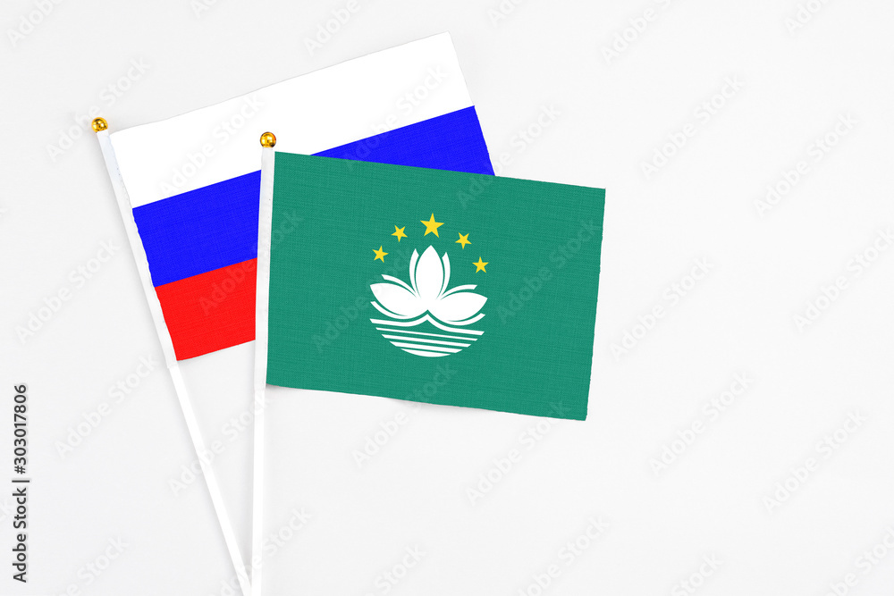 Macao and Russia stick flags on white background. High quality fabric, miniature national flag. Peaceful global concept.White floor for copy space.