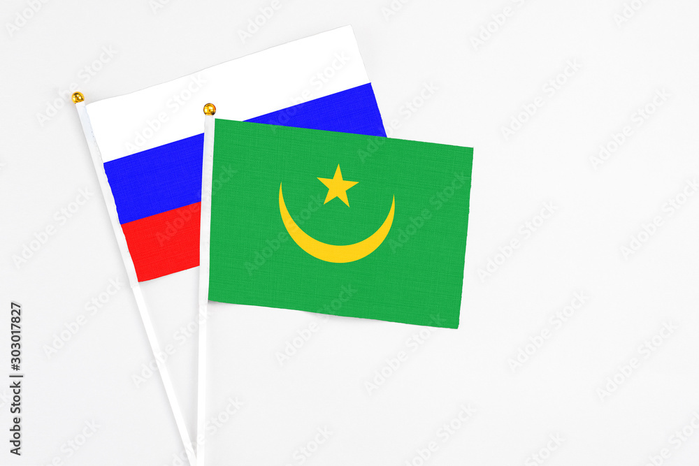 Mauritania and Russia stick flags on white background. High quality fabric, miniature national flag. Peaceful global concept.White floor for copy space. Mauritania and Russia stick flags on white background. High quality fabric, miniature national flag. Peaceful global concept.White floor for copy space.