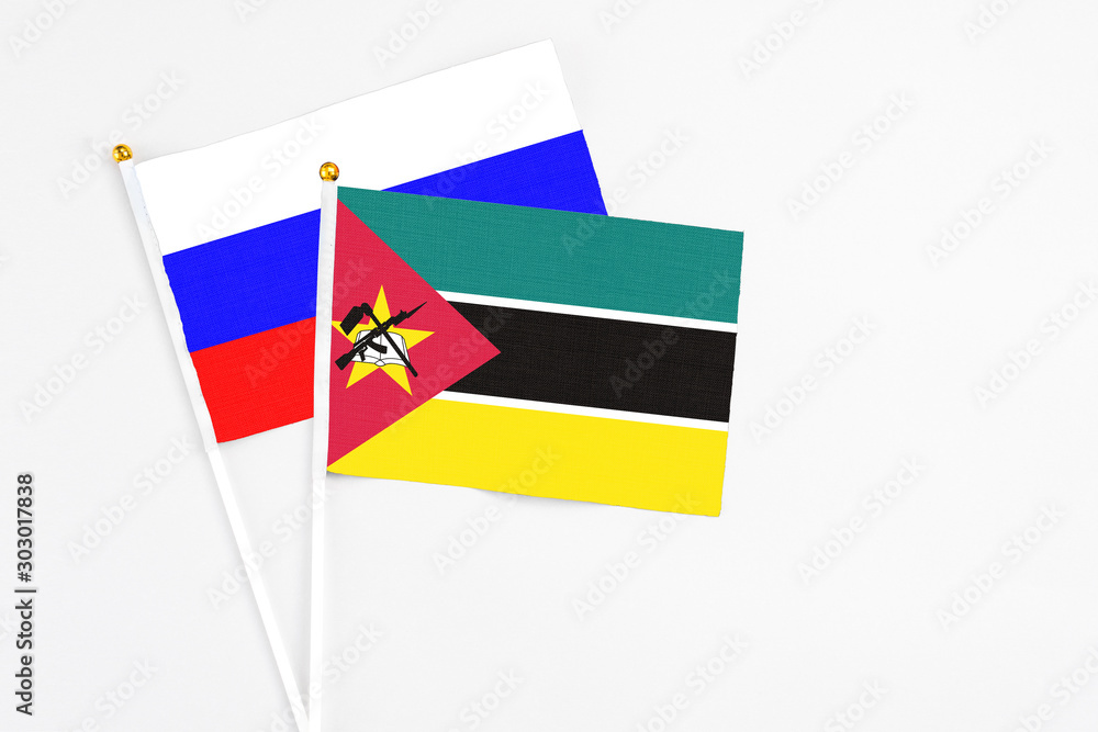 Mozambique and Russia stick flags on white background. High quality fabric, miniature national flag. Peaceful global concept.White floor for copy space. Mozambique and Russia stick flags on white background. High quality fabric, miniature national flag. Peaceful global concept.White floor for copy space.