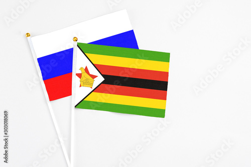 Free Download Zimbabwe and Russia stick flags on white background. High quality fabric, miniature national flag. Peaceful global concept.White floor for copy space. - GFXLoad