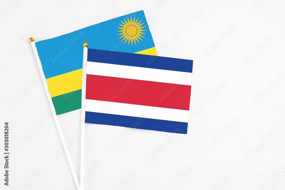 Costa Rica and Rwanda stick flags on white background. High quality fabric, miniature national flag. Peaceful global concept.White floor for copy space. Costa Rica and Rwanda stick flags on white background. High quality fabric, miniature national flag. Peaceful global concept.White floor for copy space.