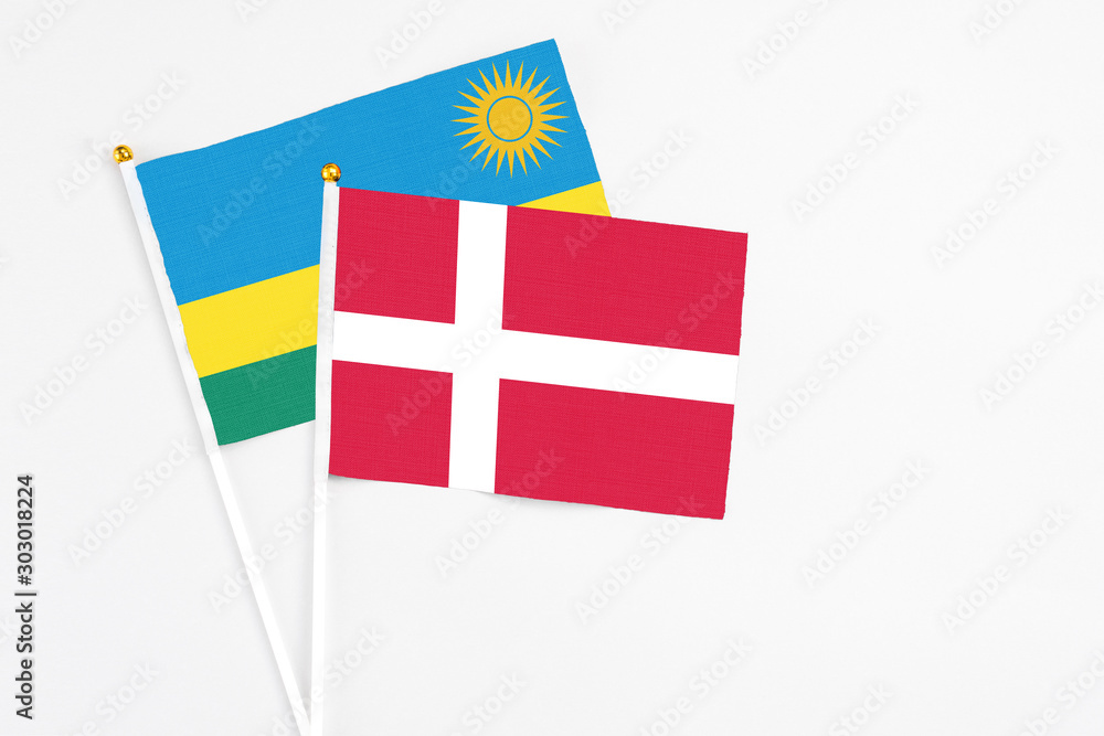 Denmark and Rwanda stick flags on white background. High quality fabric, miniature national flag. Peaceful global concept.White floor for copy space.
