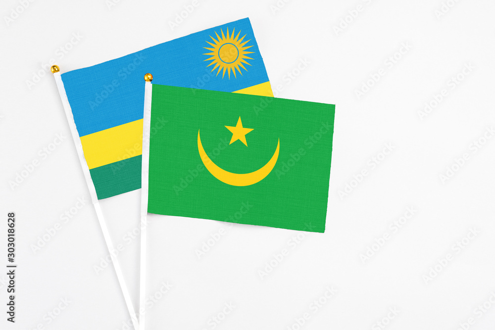 Mauritania and Rwanda stick flags on white background. High quality fabric, miniature national flag. Peaceful global concept.White floor for copy space. Mauritania and Rwanda stick flags on white background. High quality fabric, miniature national flag. Peaceful global concept.White floor for copy space.
