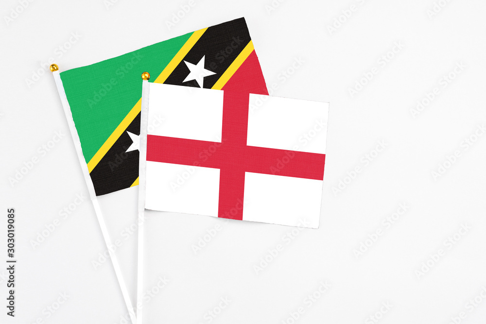 England and Saint Kitts And Nevis stick flags on white background. High quality fabric, miniature national flag. Peaceful global concept.White floor for copy space.