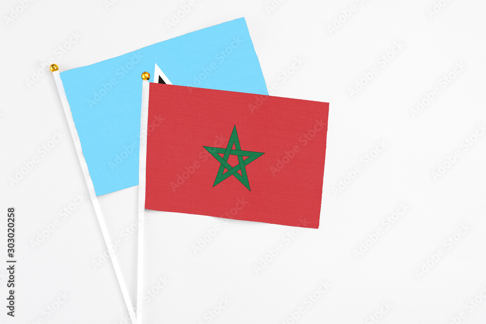 Morocco and Saint Lucia stick flags on white background. High quality fabric, miniature national flag. Peaceful global concept.White floor for copy space. Morocco and Saint Lucia stick flags on white background. High quality fabric, miniature national flag. Peaceful global concept.White floor for copy space.