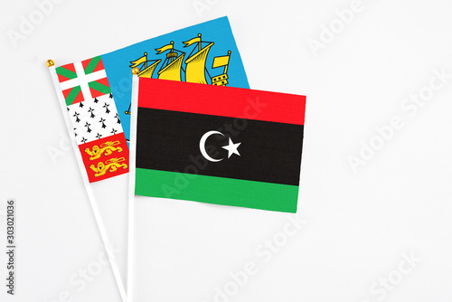 Libya and Saint Pierre And Miquelon stick flags on white background. High quality fabric, miniature national flag. Peaceful global concept.White floor for copy space.