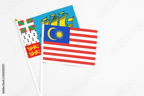 Malaysia and Saint Pierre And Miquelon stick flags on white background. High quality fabric, miniature national flag. Peaceful global concept.White floor for copy space.