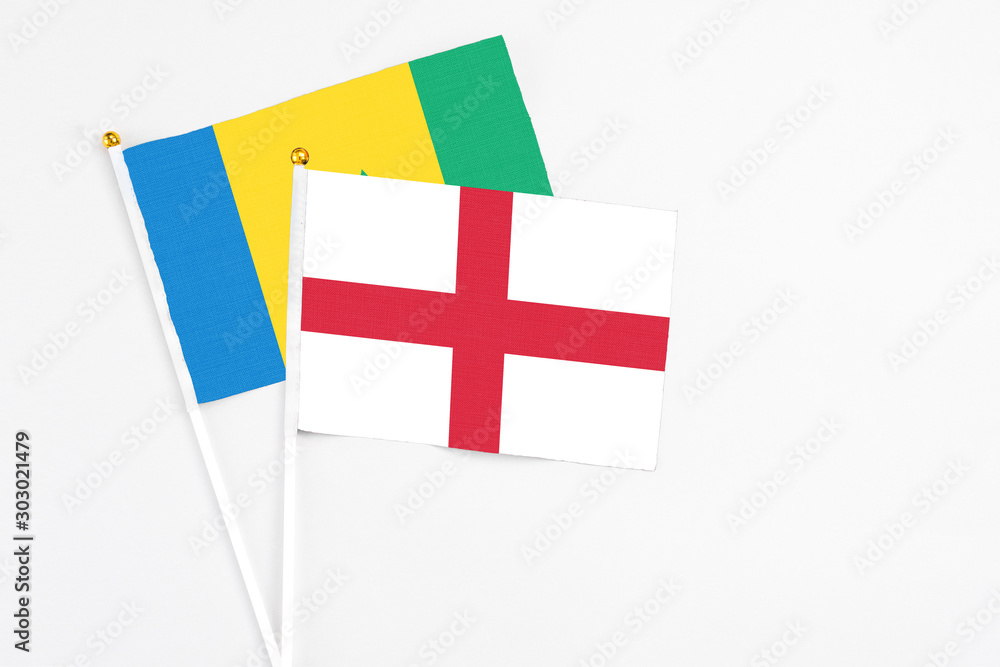 England and Saint Vincent And The Grenadines stick flags on white background. High quality fabric, miniature national flag. Peaceful global concept.White floor for copy space.