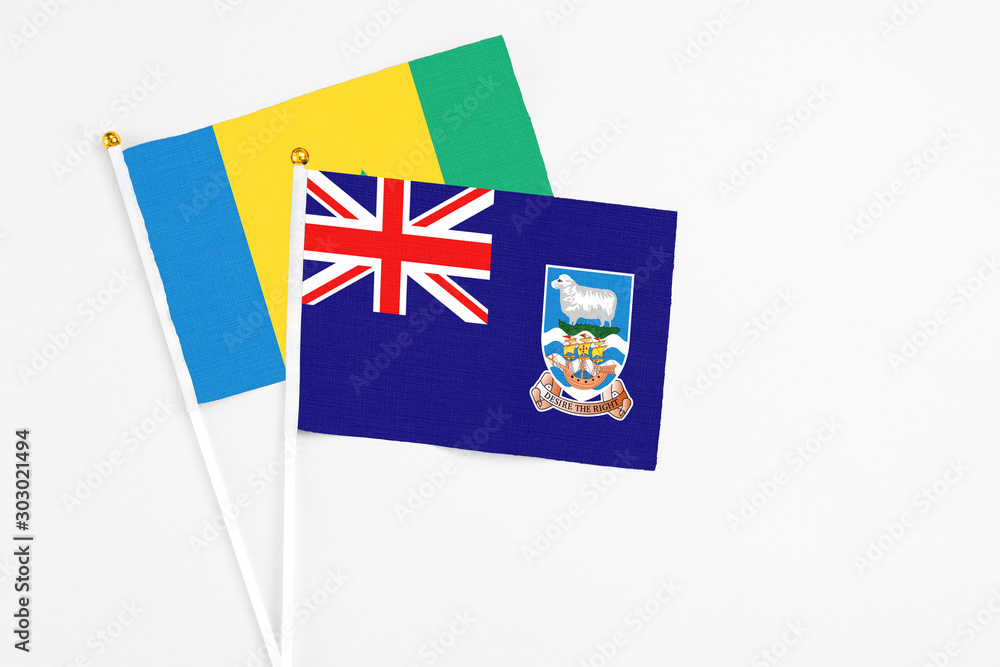 Fototapeta premium Falkland Islands and Saint Vincent And The Grenadines stick flags on white background. High quality fabric, miniature national flag. Peaceful global concept.White floor for copy space.
