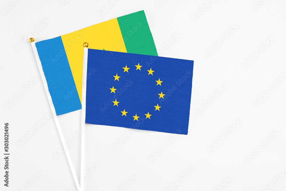 European Union and Saint Vincent And The Grenadines stick flags on white background. High quality fabric, miniature national flag. Peaceful global concept.White floor for copy space.