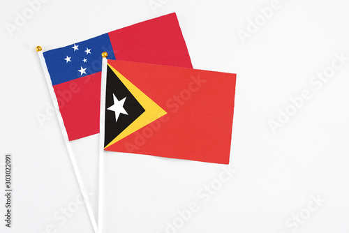 Free Download East Timor and Samoa stick flags on white background. High quality fabric, miniature national flag. Peaceful global concept.White floor for copy space. - GFXLoad