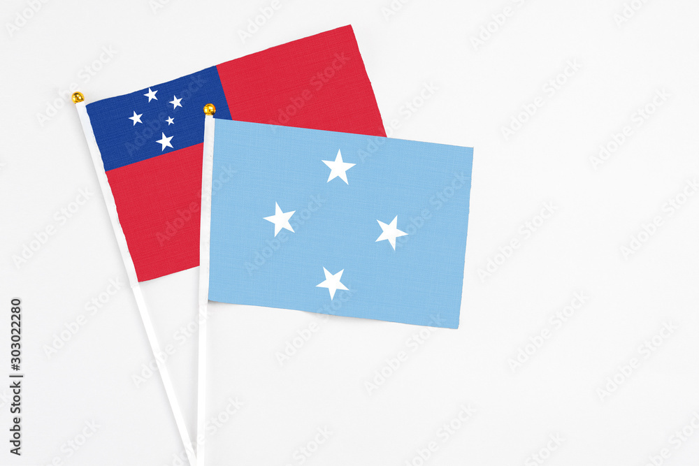 Micronesia and Samoa stick flags on white background. High quality fabric, miniature national flag. Peaceful global concept.White floor for copy space.