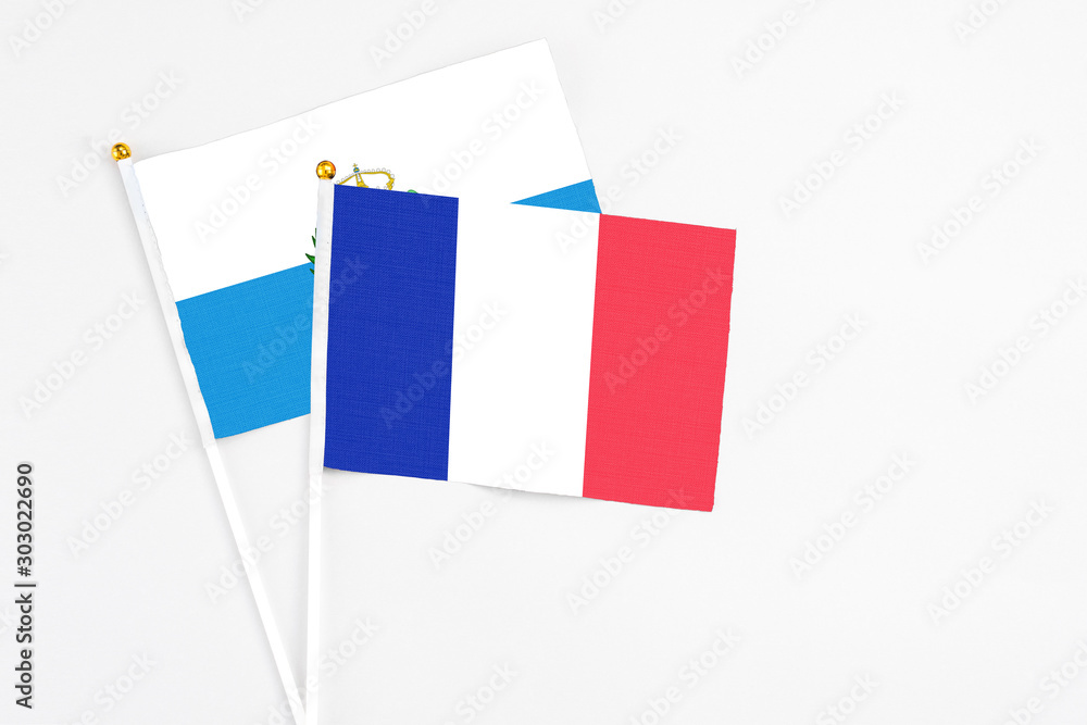 France and San Marino stick flags on white background. High quality fabric, miniature national flag. Peaceful global concept.White floor for copy space. France and San Marino stick flags on white background. High quality fabric, miniature national flag. Peaceful global concept.White floor for copy space.