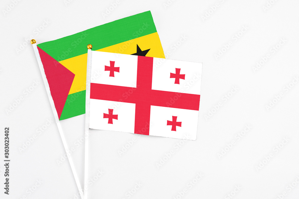 Georgia and Sao Tome And Principe stick flags on white background. High quality fabric, miniature national flag. Peaceful global concept.White floor for copy space.