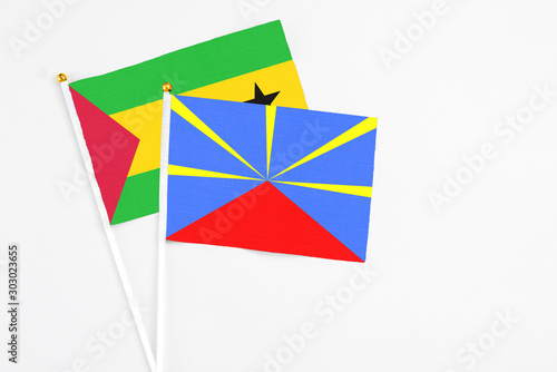 Reunion and Sao Tome And Principe stick flags on white background. High quality fabric, miniature national flag. Peaceful global concept.White floor for copy space.