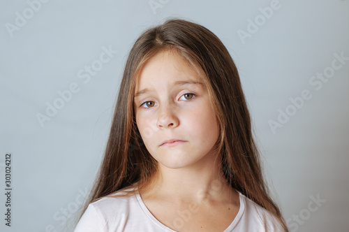 Emotional portrait of strong emotions tears of a little beautiful girl on a white background photo