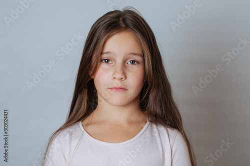 Emotional portrait of strong emotions tears of a little beautiful girl on a white background