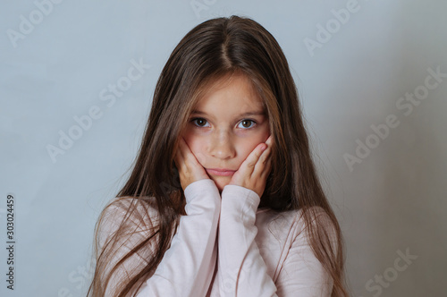 Wallpaper Mural Emotional portrait of strong emotions tears of a little beautiful girl on a white background Torontodigital.ca