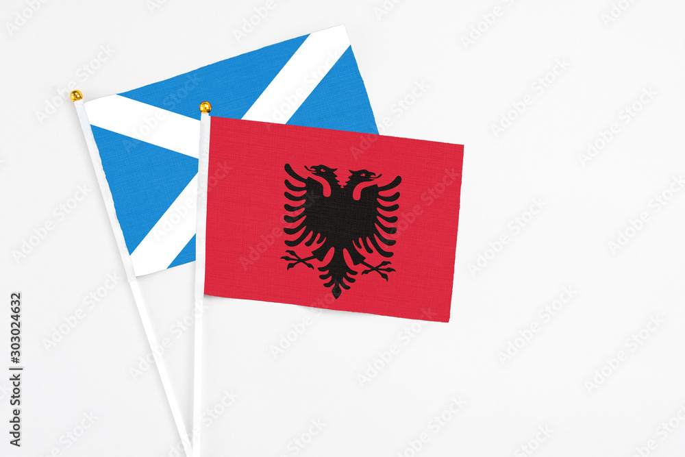Fototapeta premium Albania and Scotland stick flags on white background. High quality fabric, miniature national flag. Peaceful global concept.White floor for copy space.