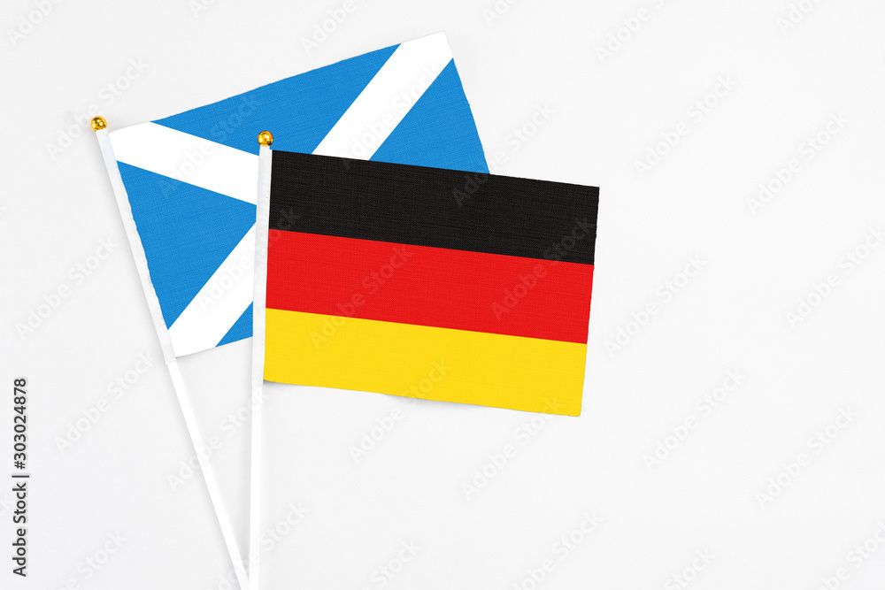Germany and Scotland stick flags on white background. High quality fabric, miniature national flag. Peaceful global concept.White floor for copy space. Germany and Scotland stick flags on white background. High quality fabric, miniature national flag. Peaceful global concept.White floor for copy space.