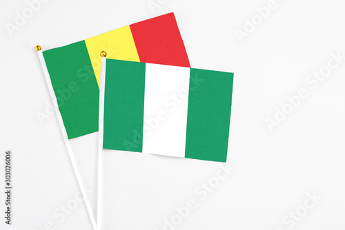 Nigeria and Senegal stick flags on white background. High quality fabric, miniature national flag. Peaceful global concept.White floor for copy space.
