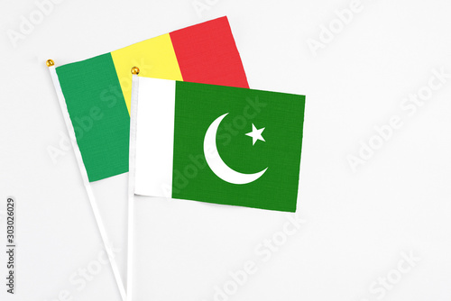 Pakistan and Senegal stick flags on white background. High quality fabric, miniature national flag. Peaceful global concept.White floor for copy space.