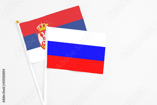 Russia and Serbia stick flags on white background. High quality fabric  miniature national flag. Peaceful global concept.White floor for copy space.