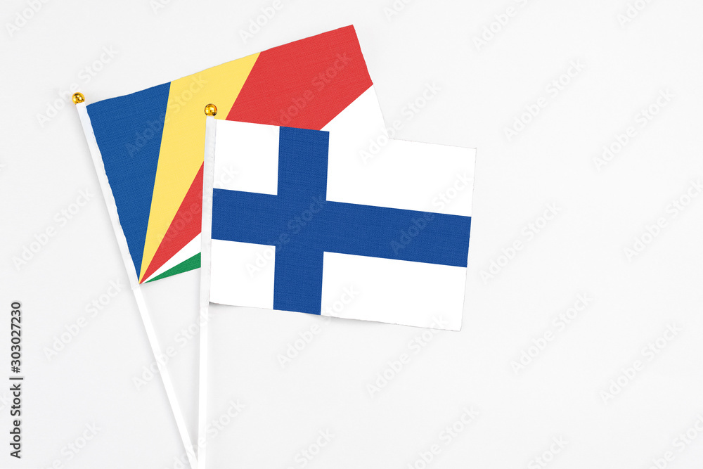 Finland and Seychelles stick flags on white background. High quality fabric, miniature national flag. Peaceful global concept.White floor for copy space.v