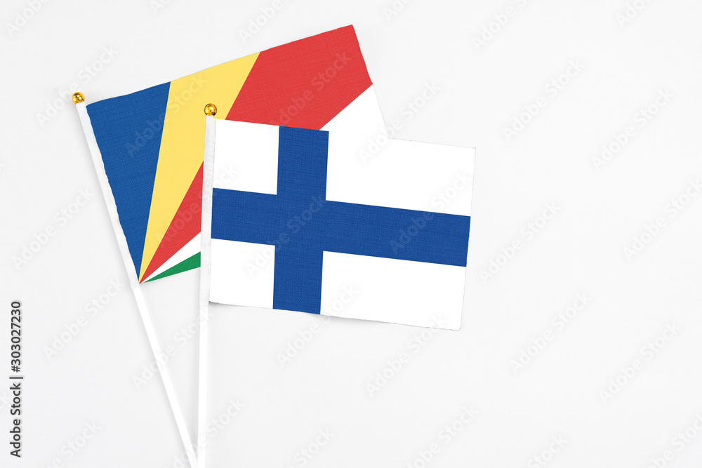 Finland and Seychelles stick flags on white background. High quality fabric, miniature national flag. Peaceful global concept.White floor for copy space.v Finland and Seychelles stick flags on white background. High quality fabric, miniature national flag. Peaceful global concept.White floor for copy space.v