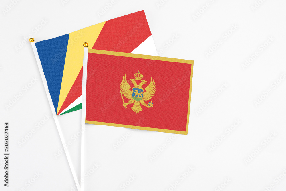 Montenegro and Seychelles stick flags on white background. High quality fabric, miniature national flag. Peaceful global concept.White floor for copy space.v Montenegro and Seychelles stick flags on white background. High quality fabric, miniature national flag. Peaceful global concept.White floor for copy space.v