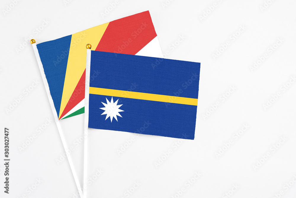 Nauru and Seychelles stick flags on white background. High quality fabric, miniature national flag. Peaceful global concept.White floor for copy space.v Nauru and Seychelles stick flags on white background. High quality fabric, miniature national flag. Peaceful global concept.White floor for copy space.v