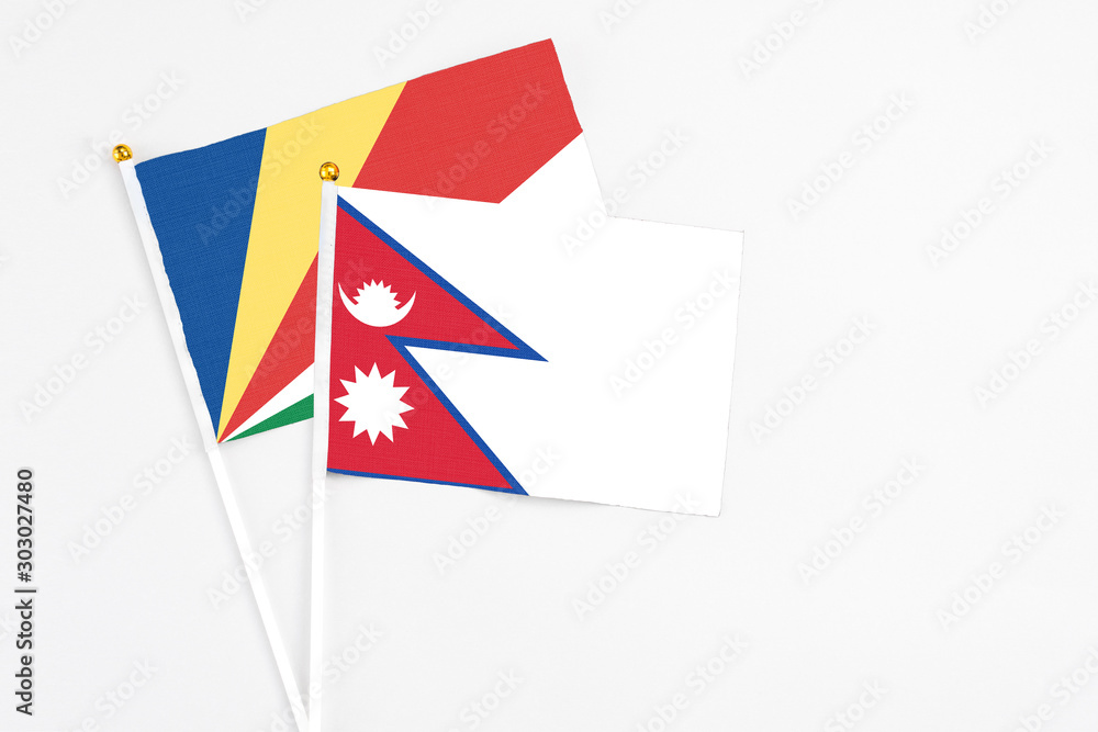 Nepal and Seychelles stick flags on white background. High quality fabric, miniature national flag. Peaceful global concept.White floor for copy space.v Nepal and Seychelles stick flags on white background. High quality fabric, miniature national flag. Peaceful global concept.White floor for copy space.v