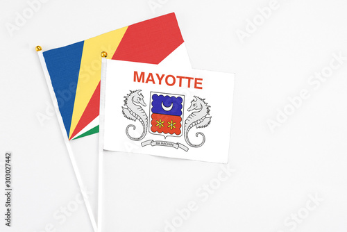 Mayotte and Seychelles stick flags on white background. High quality fabric, miniature national flag. Peaceful global concept.White floor for copy space.v