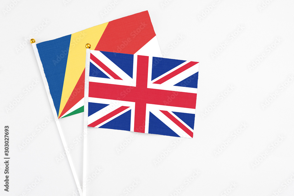 United Kingdom and Seychelles stick flags on white background. High quality fabric, miniature national flag. Peaceful global concept.White floor for copy space.v United Kingdom and Seychelles stick flags on white background. High quality fabric, miniature national flag. Peaceful global concept.White floor for copy space.v
