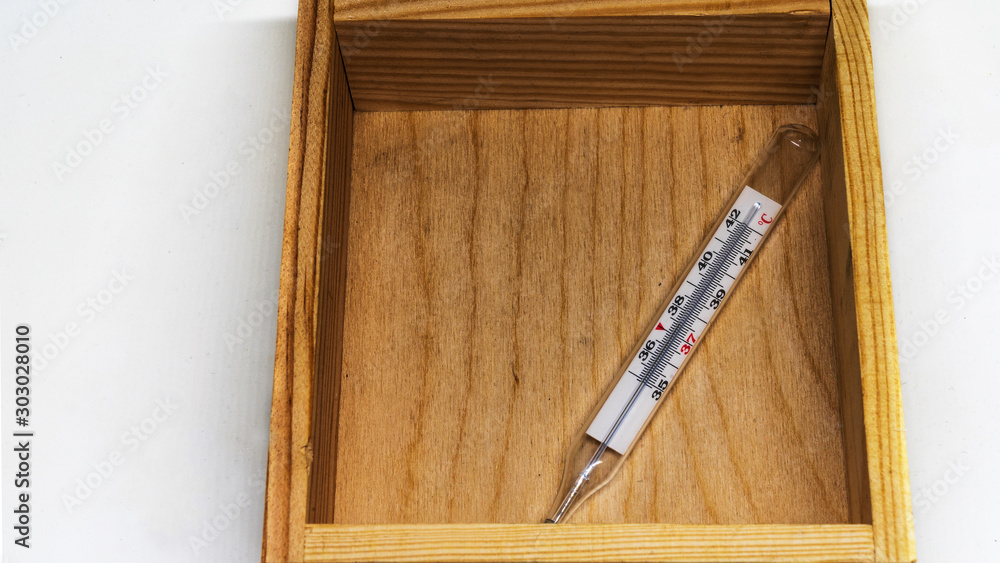 Thermometers in wooden box lying on white background.