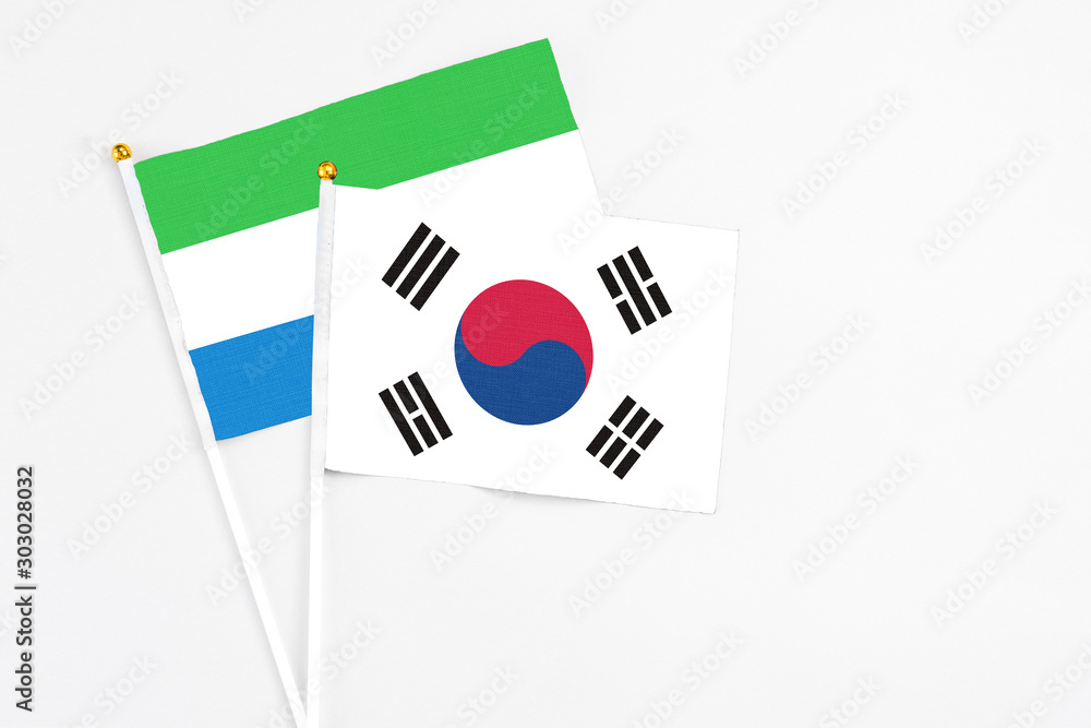South Korea and Sierra Leone stick flags on white background. High quality fabric, miniature national flag. Peaceful global concept.White floor for copy space.