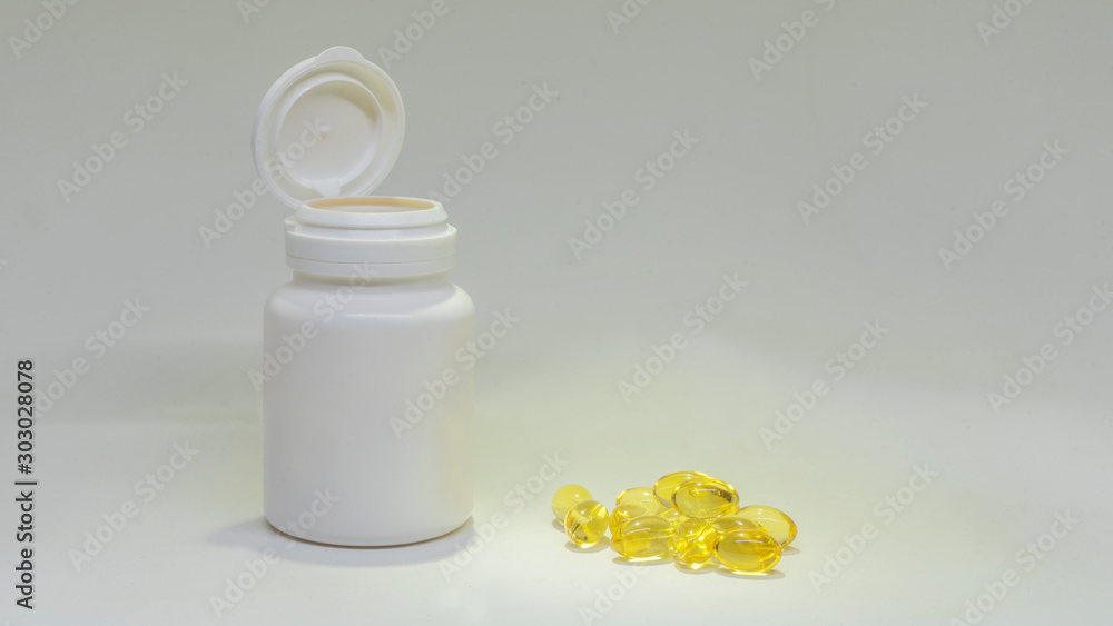 White jar of pills and fish oil pills on white background. White medical containers. White jar of pills and fish oil pills on white background. White medical containers.