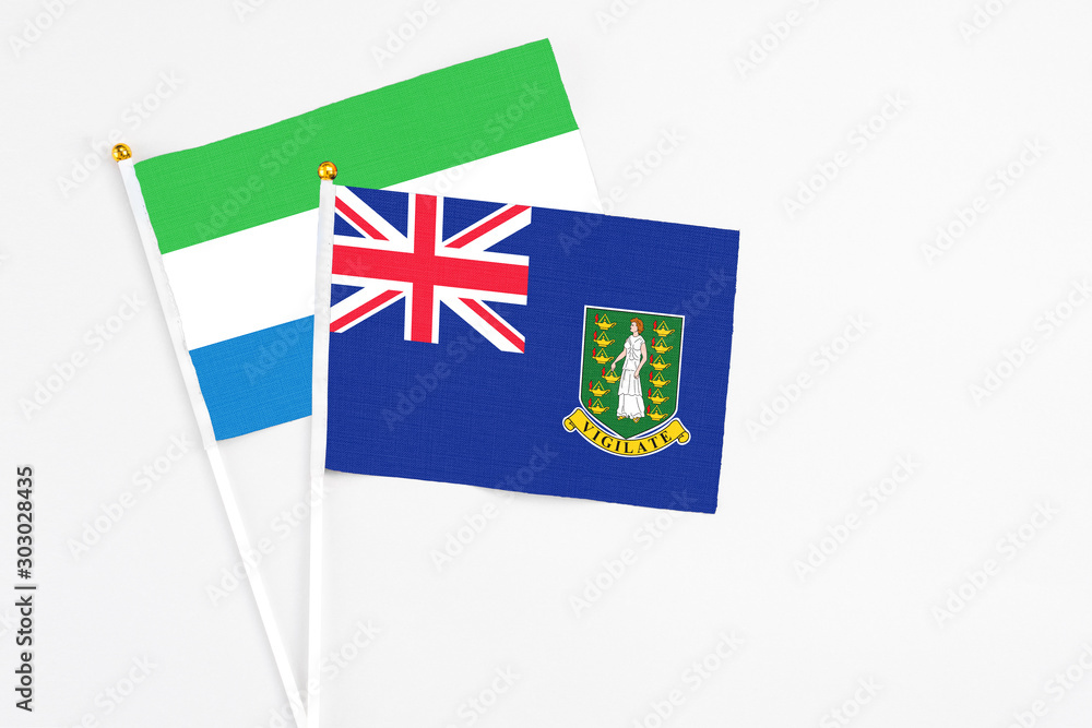 Fototapeta premium British Virgin Islands and Sierra Leone stick flags on white background. High quality fabric, miniature national flag. Peaceful global concept.White floor for copy space.