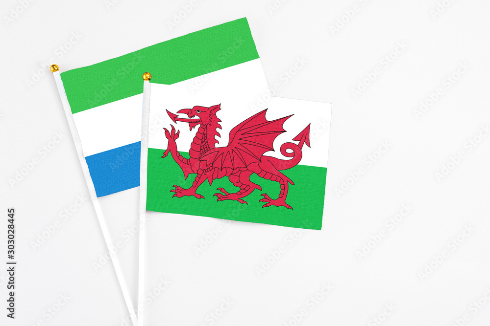 Wales and Sierra Leone stick flags on white background. High quality fabric, miniature national flag. Peaceful global concept.White floor for copy space. Wales and Sierra Leone stick flags on white background. High quality fabric, miniature national flag. Peaceful global concept.White floor for copy space.