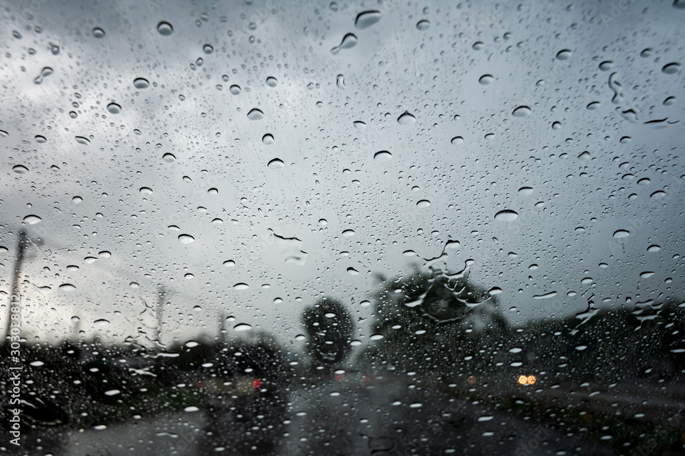 Raindrops on the car glass while driving through heavy rain and storm surges. Raindrops on the car glass while driving through heavy rain and storm surges.