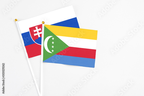 Free Download Comoros and Slovakia stick flags on white background. High quality fabric, miniature national flag. Peaceful global concept.White floor for copy space. - GFXLoad