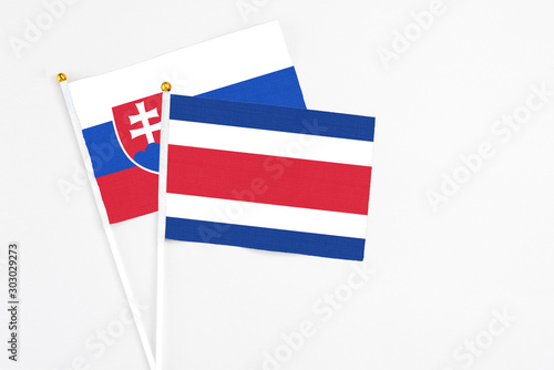 Costa Rica and Slovakia stick flags on white background. High quality fabric, miniature national flag. Peaceful global concept.White floor for copy space. photo