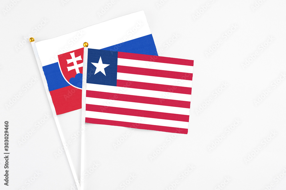 Liberia and Slovakia stick flags on white background. High quality fabric, miniature national flag. Peaceful global concept.White floor for copy space. Liberia and Slovakia stick flags on white background. High quality fabric, miniature national flag. Peaceful global concept.White floor for copy space.