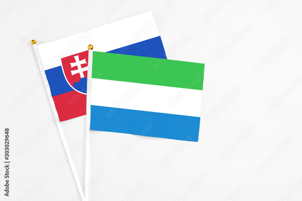 Sierra Leone and Slovakia stick flags on white background. High quality fabric, miniature national flag. Peaceful global concept.White floor for copy space. Sierra Leone and Slovakia stick flags on white background. High quality fabric, miniature national flag. Peaceful global concept.White floor for copy space.