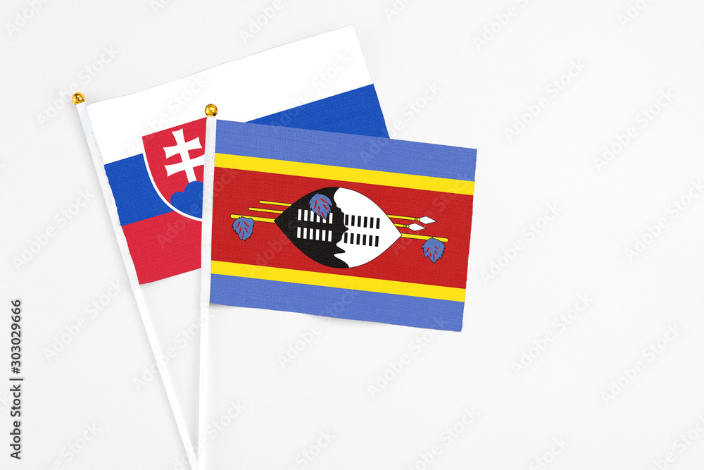 Fototapeta premium Swaziland and Slovakia stick flags on white background. High quality fabric, miniature national flag. Peaceful global concept.White floor for copy space.