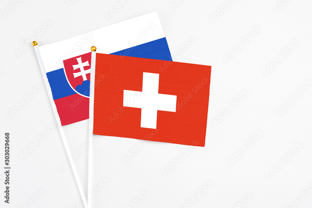 Switzerland and Slovakia stick flags on white background. High quality fabric, miniature national flag. Peaceful global concept.White floor for copy space.