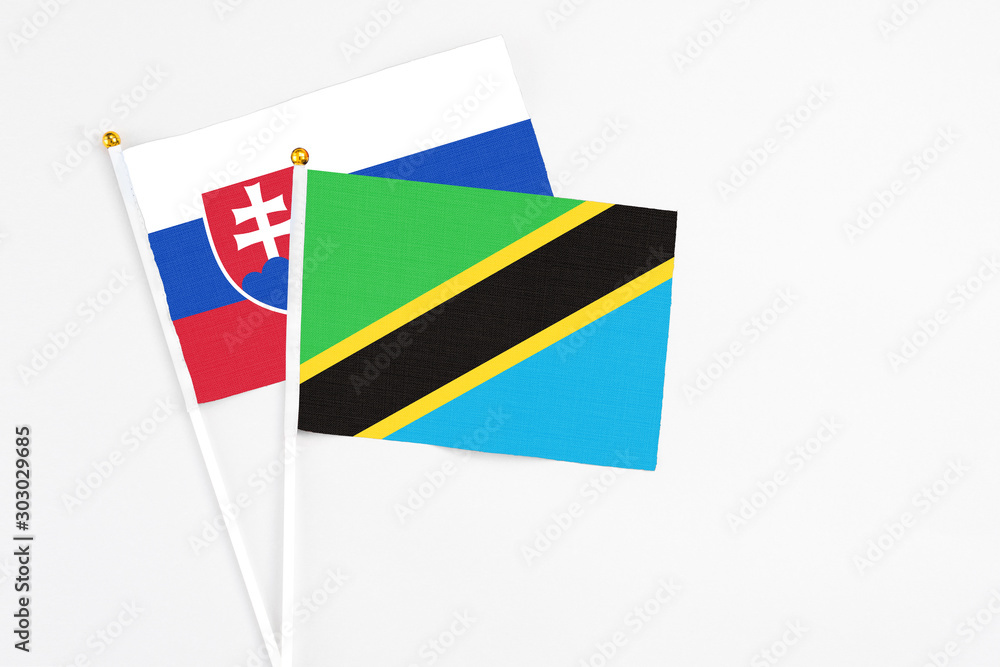 Tanzania and Slovakia stick flags on white background. High quality fabric, miniature national flag. Peaceful global concept.White floor for copy space. Tanzania and Slovakia stick flags on white background. High quality fabric, miniature national flag. Peaceful global concept.White floor for copy space.