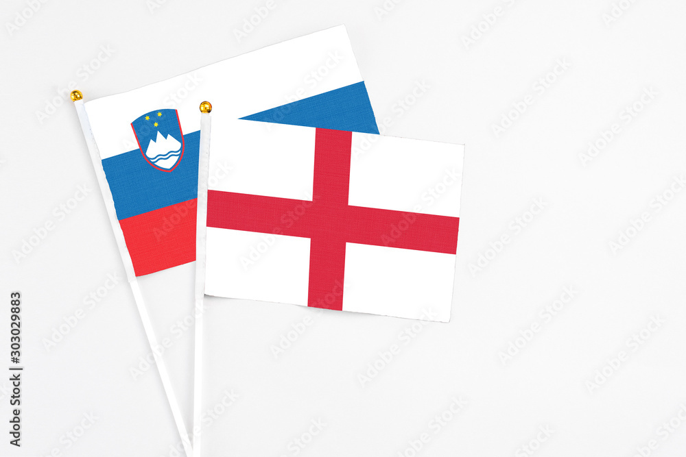 England and Slovenia stick flags on white background. High quality fabric, miniature national flag. Peaceful global concept.White floor for copy space.