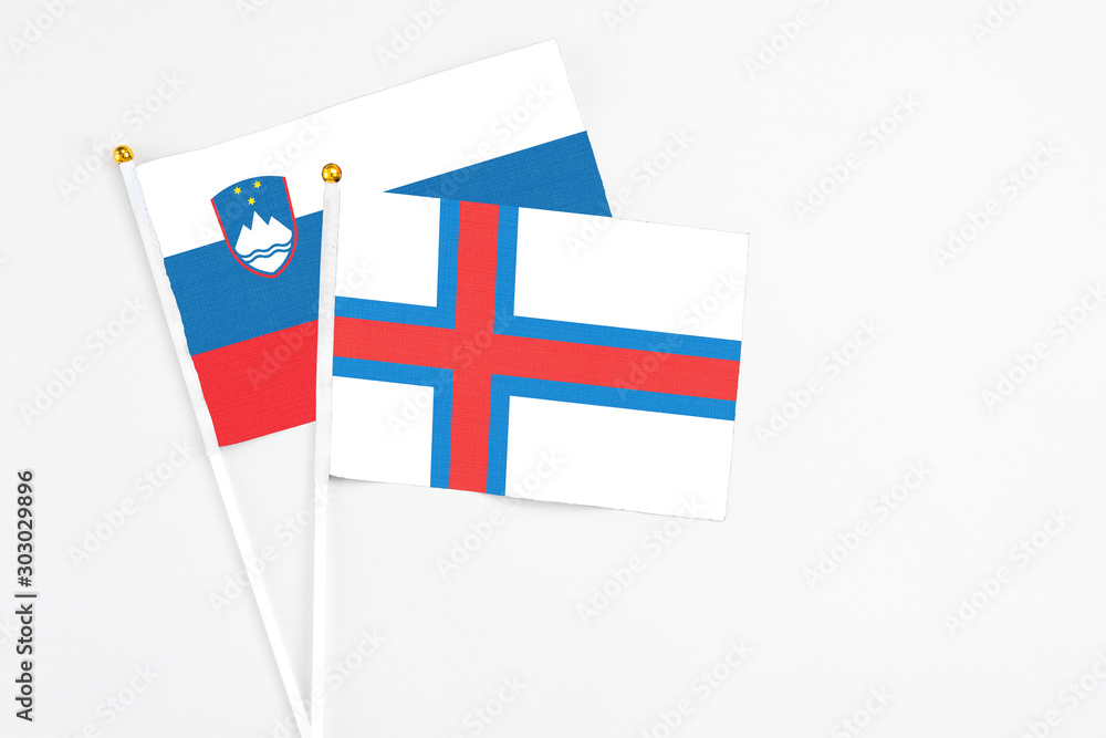 Faroe Islands and Slovenia stick flags on white background. High quality fabric, miniature national flag. Peaceful global concept.White floor for copy space. Faroe Islands and Slovenia stick flags on white background. High quality fabric, miniature national flag. Peaceful global concept.White floor for copy space.