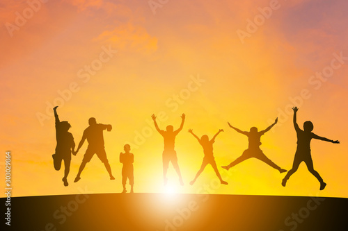 Silhouette of a Family with children and friend playing with sunset background.